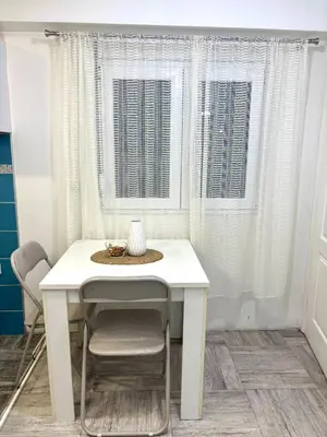 a white table and chairs in a room with a window at Apartman Helena 2 in Lazarevac