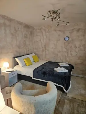 a bedroom with a bed with yellow pillows and a chair at Apartman Helena 2 in Lazarevac