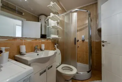 a bathroom with a sink and a toilet and a shower at Spacious Family Apartment in Belgrade