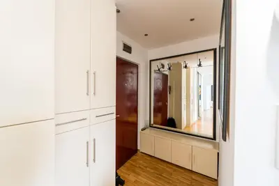 a bathroom with white cabinets and a large mirror at Spacious Family Apartment in Belgrade