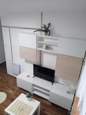 a living room with white furniture and a tv at Small low cost studio Dorcol in Belgrade