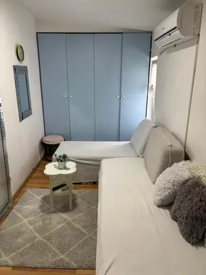 a small room with two beds and a table at Small low cost Dorcol in Belgrade