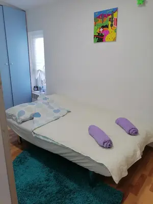 a bed in a room with purple pillows on it at Small low cost Dorcol in Belgrade