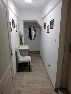 a hallway with a table and a chair and a mirror at Small low cost Dorcol in Belgrade