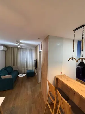 a living room with a blue couch and a table at Exing Prime 65 New Belgrade in Belgrade