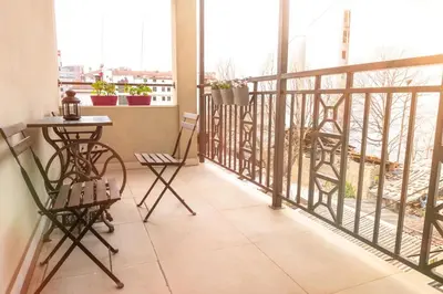 a balcony with a table and chairs on a balcony at Center 2BDR additional living Room King bed 4 pers in Belgrade