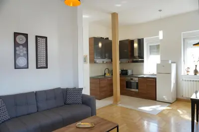 a living room with a couch and a kitchen at Center 2BDR additional living Room King bed 4 pers in Belgrade