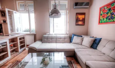 a living room with a couch and a glass table at Crown Apartment - Your Royal Stay in Belgrade