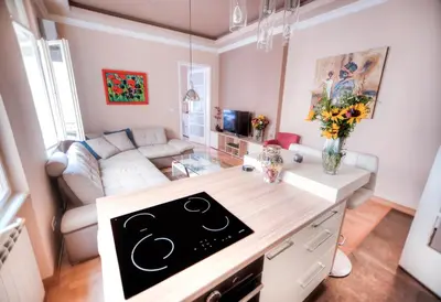 a kitchen and living room with a stove top oven at Crown Apartment - Your Royal Stay in Belgrade