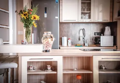 a kitchen with a counter with a vase of flowers at Crown Apartment - Your Royal Stay in Belgrade