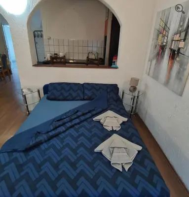a bedroom with a blue bed with towels on it at Konza1 in Belgrade