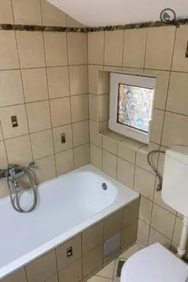 a bathroom with a tub and a toilet and a window at Konza 2 in Belgrade