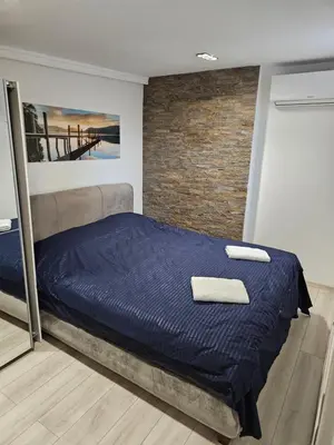 a bed in a room with a brick wall at Rabit delux I in Belgrade