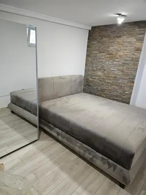 a large bed in a room with a brick wall at Rabit delux I in Belgrade