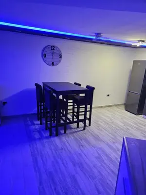 a dining room table with chairs and a clock on the wall at Rabit delux I in Belgrade
