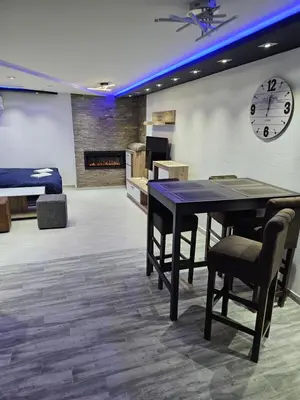 a room with a table and chairs and a clock at Rabit delux I in Belgrade