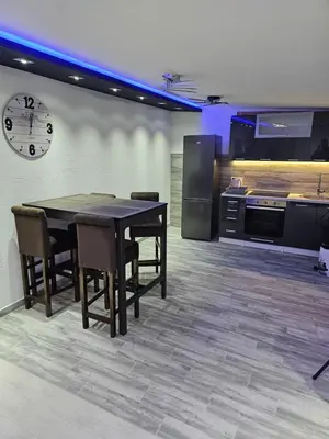 a kitchen with a table and chairs and a clock at Rabit delux I in Belgrade