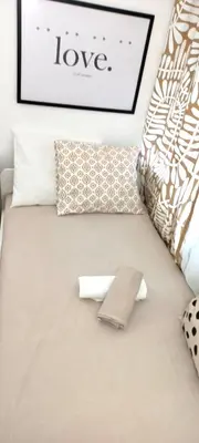 a bed with pillows and a sign that reads love at Rooms & Apartments Miavik in Belgrade