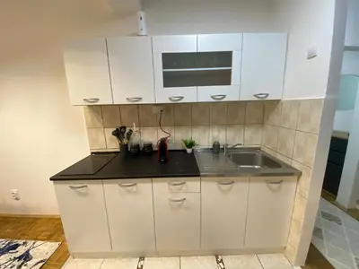 a kitchen with white cabinets and a sink at Prestige in Belgrade