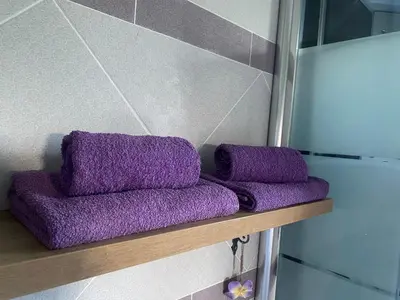 two purple towels sitting on a shelf in a bathroom at Apartman LIMA in Belgrade