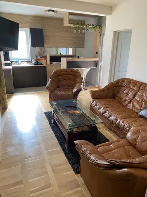 a living room with brown leather couches and a table at Apartman LIMA in Belgrade