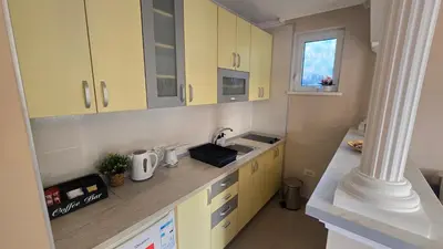 a kitchen with yellow cabinets and a counter top at Warm Nest in Belgrade