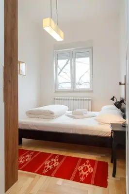 a large bed in a room with a red rug at 155sqm 4BR Central Belgrade Apartment for 9 Guests in Belgrade