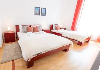 a bedroom with two beds and a couch at 155sqm 4BR Central Belgrade Apartment for 9 Guests in Belgrade