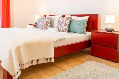 a bedroom with a bed with pillows and a dresser at 155sqm 4BR Central Belgrade Apartment for 9 Guests in Belgrade