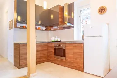 a kitchen with wooden cabinets and a white refrigerator at 155sqm 4BR Central Belgrade Apartment for 9 Guests in Belgrade