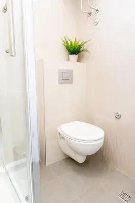 a bathroom with a toilet and a plant on a shelf at 155sqm 4BR Central Belgrade Apartment for 9 Guests in Belgrade