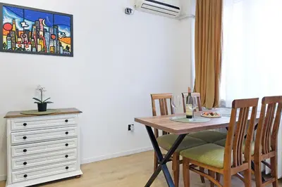 a dining room with a table and chairs and a dresser at Apartment Paradise Flora Centar in Belgrade
