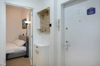 a bedroom with a bed and a door leading into a room at Apartment Paradise Flora Centar in Belgrade