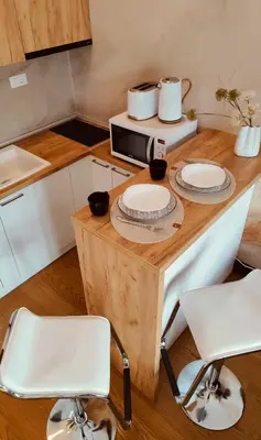 a kitchen with a wooden table with two white chairs at Residence in Belgrade