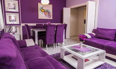 a purple living room with purple couches and a table at Apartment Avala in Belgrade