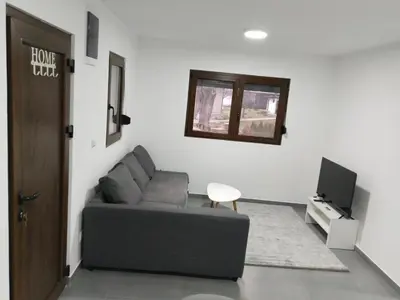 a living room with a couch and a television at New Belgrade Apartman - Near the Airport in Belgrade