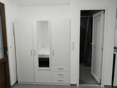 a white cabinet in a room with a mirror at New Belgrade Apartman - Near the Airport in Belgrade