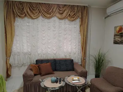 a living room with a couch and a large window at STAN NA DAN - Garsonjera PRAMAC in Žarkovo