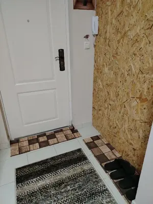 a bathroom with a white door and a tile floor at STAN NA DAN - Garsonjera PRAMAC in Žarkovo