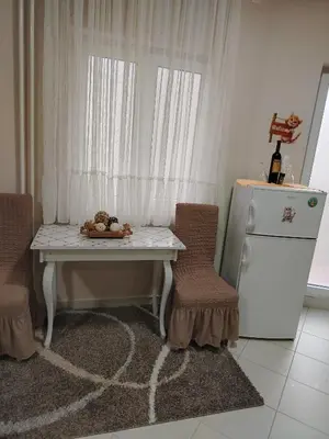 a kitchen with a table and two chairs and a refrigerator at STAN NA DAN - Garsonjera PRAMAC in Žarkovo