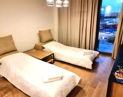 a hotel room with two beds and a chair at Beograd Waterfront Verde in Belgrade