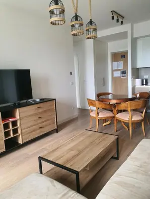 a living room with a dining room table and a tv at Beograd Waterfront Verde in Belgrade