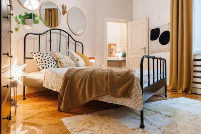 a bedroom with a bed and mirrors on the wall at Musical Shelter with Balcony 2min to Republic Square in Belgrade