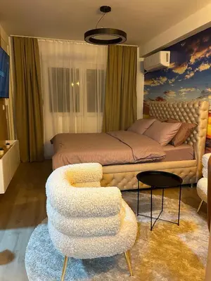 a bedroom with a bed and a chair and a couch at Diamond airport JACUZZI&SAUNA apartman Ledine in Ledine