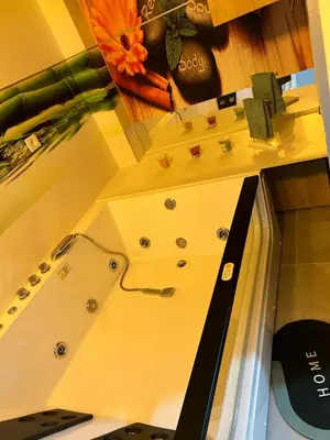a bath tub with a sink in a room at Diamond airport JACUZZI&SAUNA apartman Ledine in Ledine