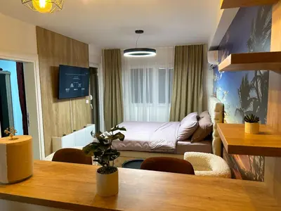 a small room with a bed and a table in a room at Diamond airport JACUZZI&SAUNA apartman Ledine in Ledine