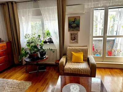 a living room with a chair and a table and windows at Mara apartment, Belgrade, New belgrade in Belgrade