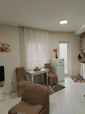 a kitchen with a table and chairs and a refrigerator at Apartman PRAMAC in Belgrade