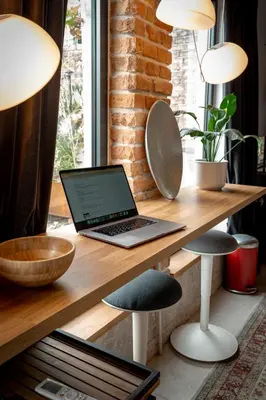 a laptop computer sitting on a wooden desk with stools at BGLAB Small Rooftop in Belgrade