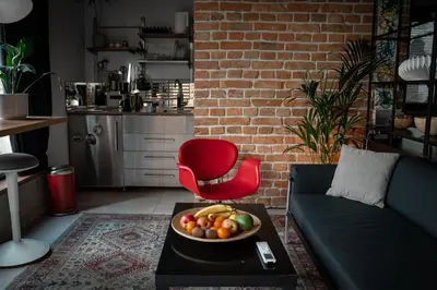 a living room with a red chair and a bowl of fruit at BGLAB Small Rooftop in Belgrade